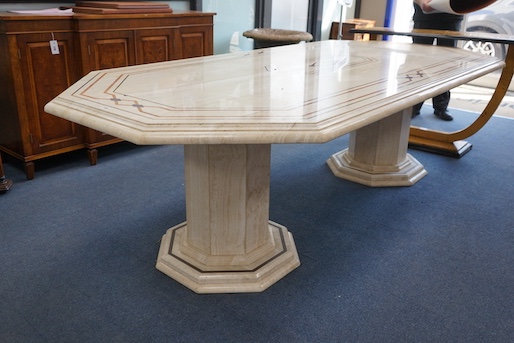 A Travertine marble dining table of elongated octagonal form on twin octagonal column supports, length 260cm, depth 120cm, height 74cm